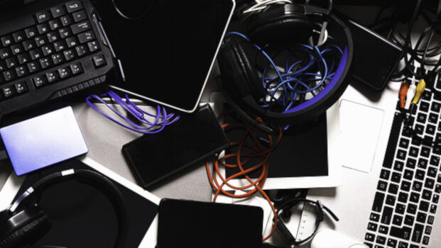 Old computers, digital tablets, mobile phones, many used electronic gadgets devices, broken household and appliances on gray background. Planned obsolescence, electronic waste for recycling concept